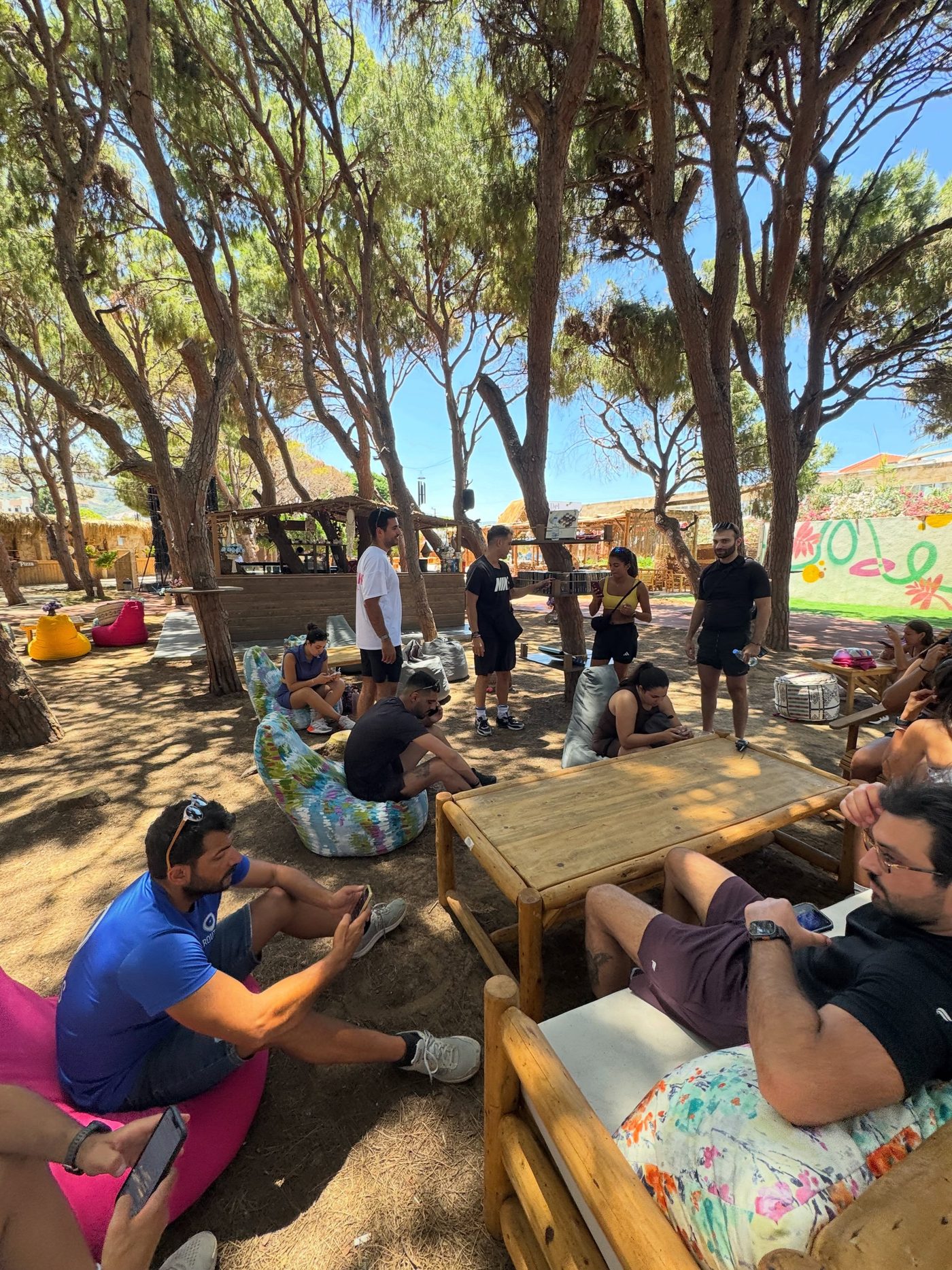 Riders resting under pine trees after a BCB ride
