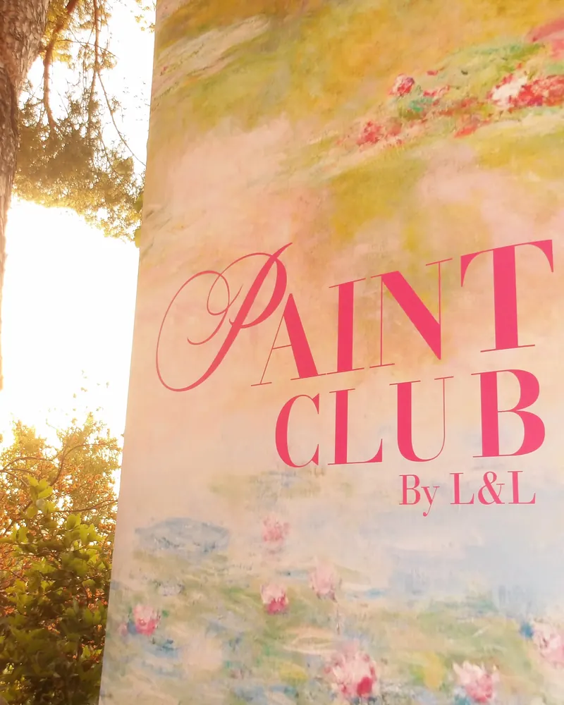 The Paint Club by L&L banner, backlit by the last of the sun